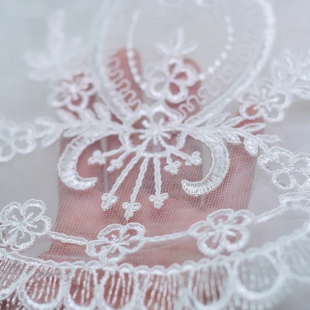 Close-up shot of delicate Baroque floral embroidered lace appliques along scalloped veil hemline