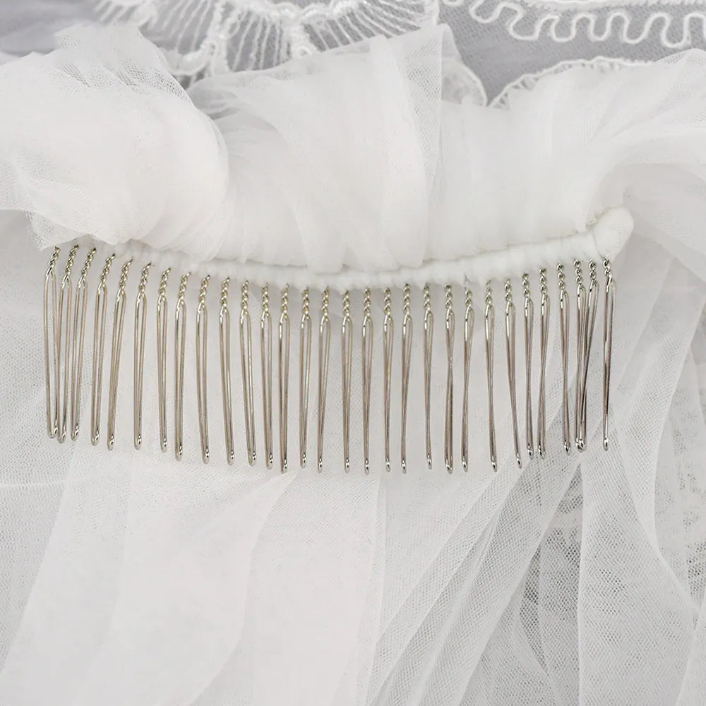 Macro close-up view of sturdy silver metal comb hand-stitched into gathered white tulle mesh
