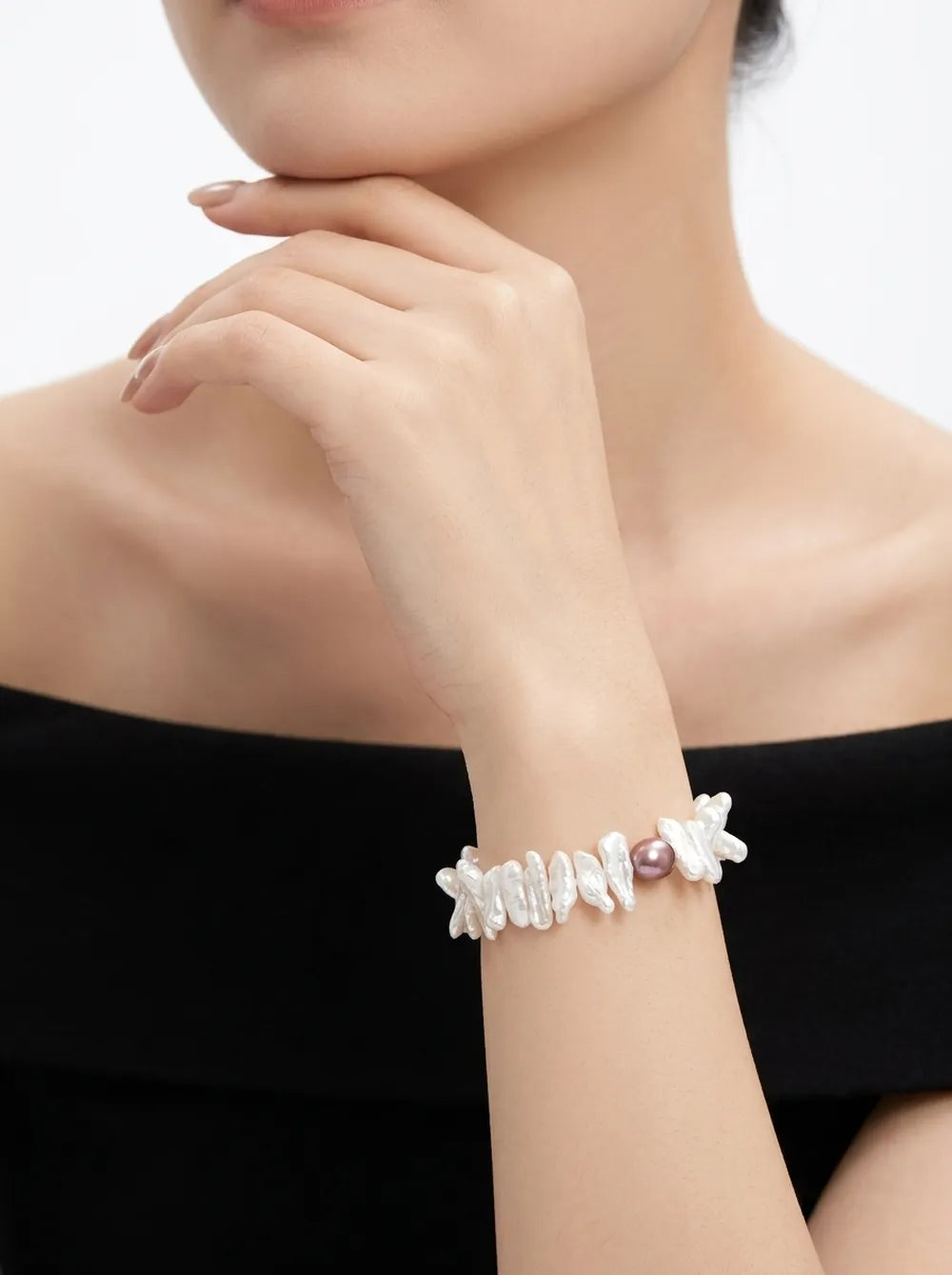 Stick baroque pearl elastic bracelet displayed on a clear acrylic board alongside a matching strand.