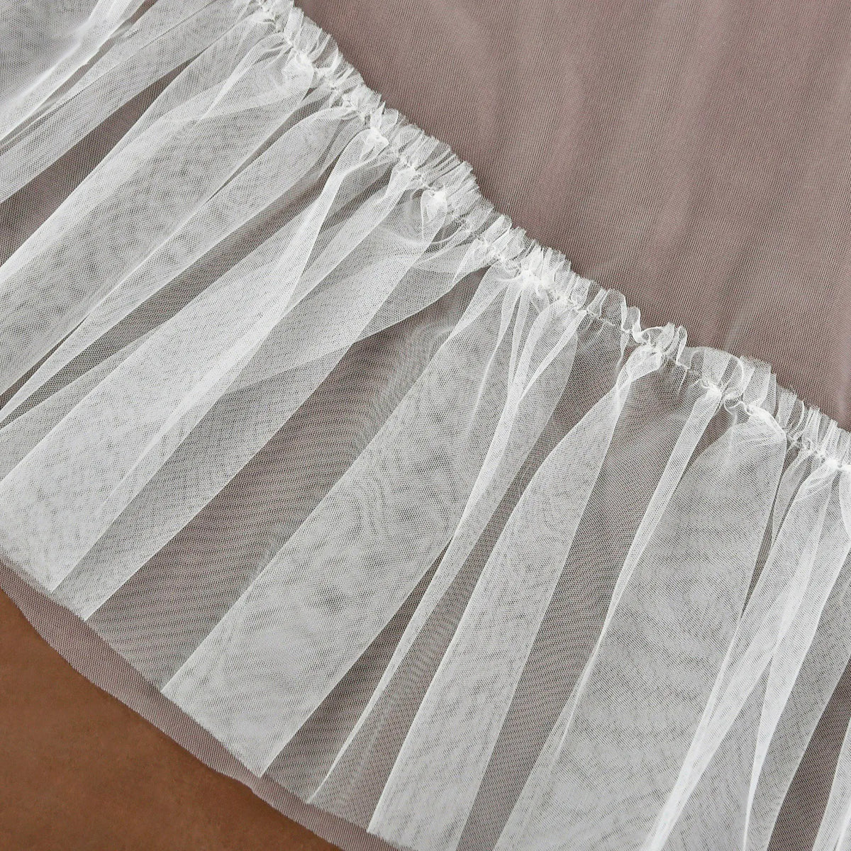 Close up detail of soft tulle texture and gathered ruffle border seam