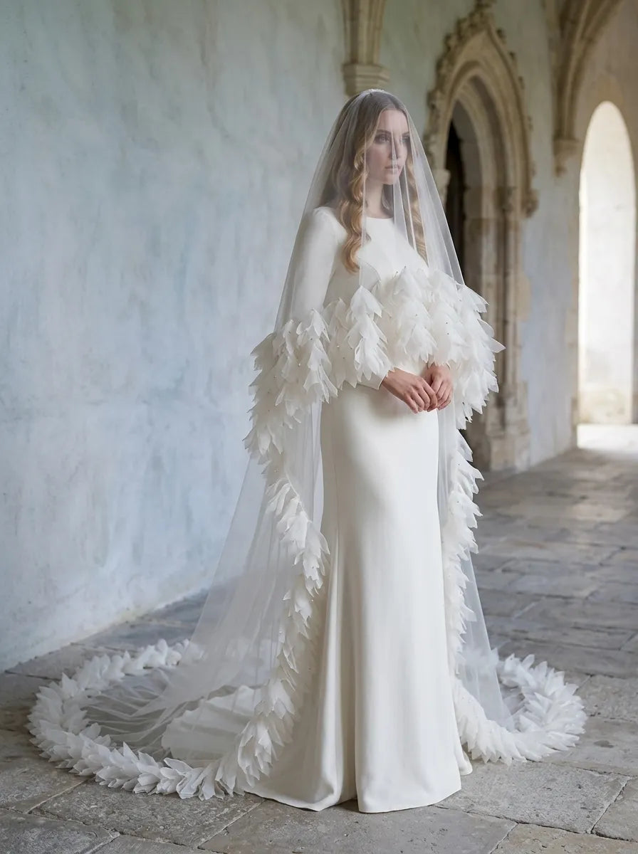 Side perspective of bride in classic archway wearing dramatic tiered ruffle cathedral veil