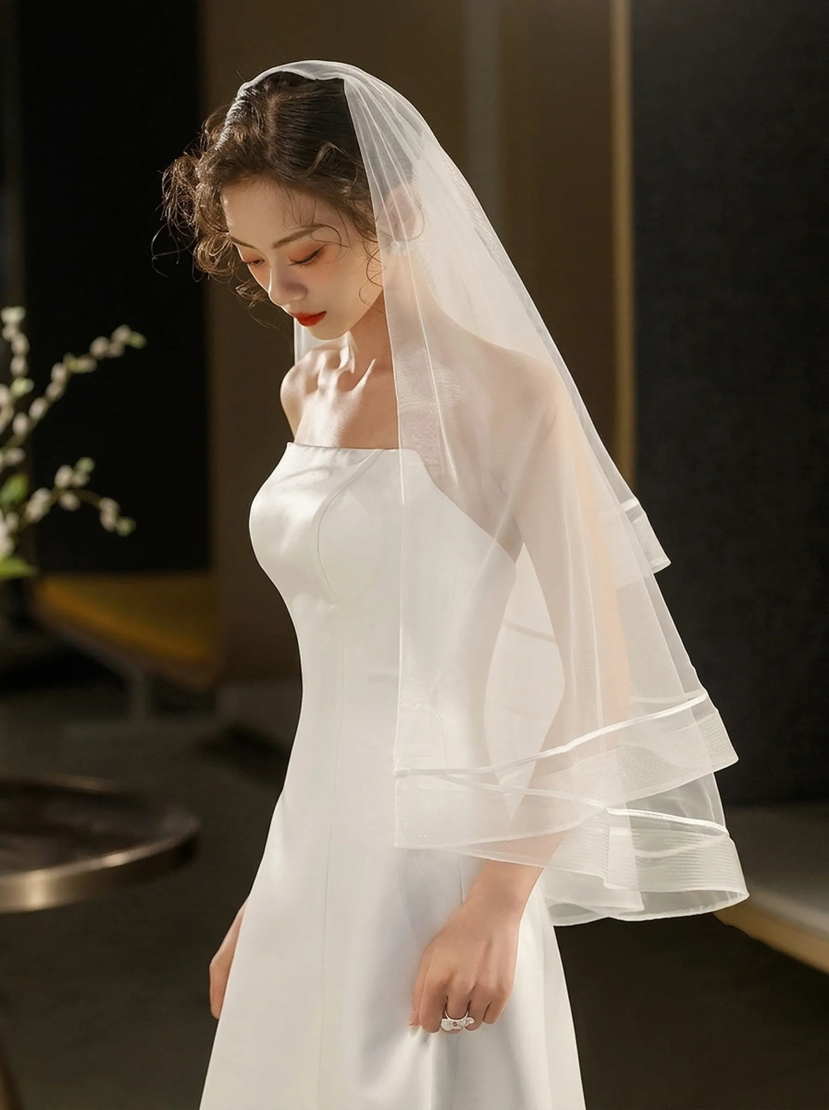 Bride wearing an off white two tier wedding veil with romantic short blusher style