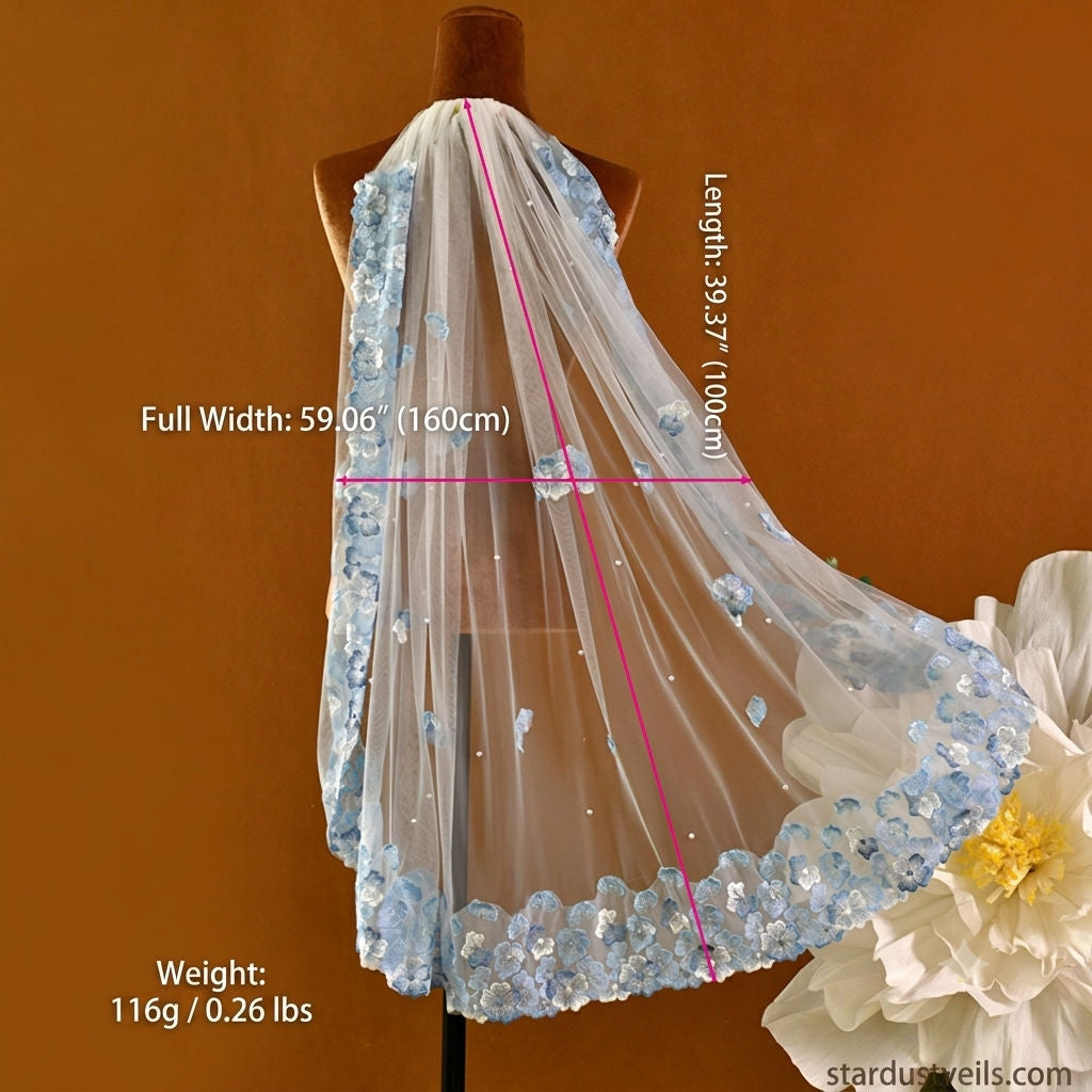 Whimsical romantic single-tier fingertip length bridal veil adorned with blue 3D embroidered floral lace along the edge and scattered lustrous pearl seed accents.